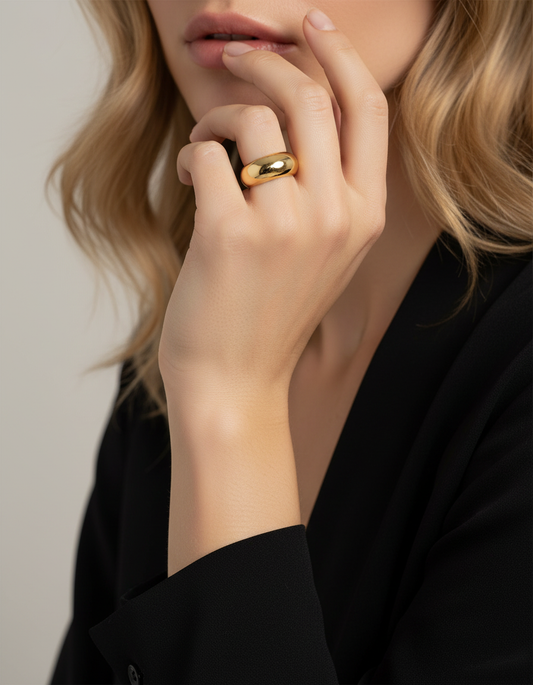 Woman with blonde hair wearing black blouse with single gold cloud ring on ring finger